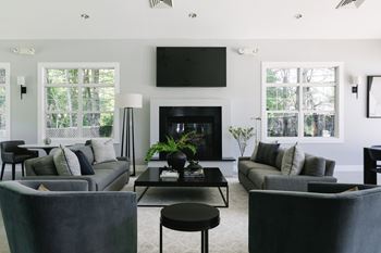 A modern living room with a fireplace and a television mounted above it.